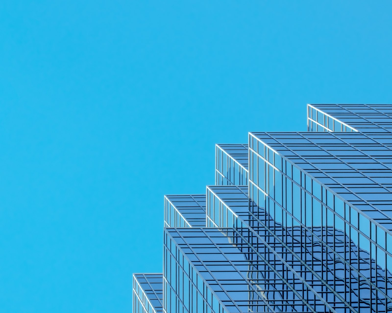 Modern glass skyscraper against a clear blue sky